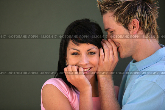 man telling a secret to his girlfriend. Стоковое фото, агентство Ingram Publishing / Фотобанк Лори