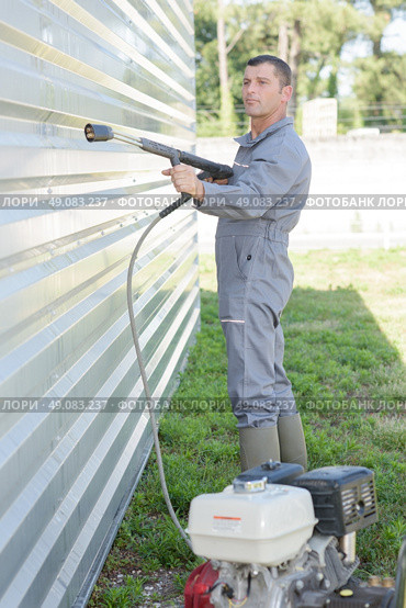 Man using pressure washer. Стоковое фото, агентство Ingram Publishing / Фотобанк Лори