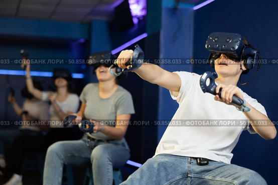 Man using virtual reality glasses delighted with videogames and new tech. Стоковое фото, фотограф Яков Филимонов / Фотобанк Лори