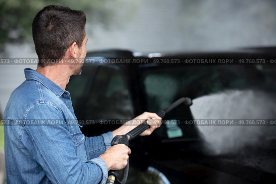 man washing his car under high pressure water outdoors. Стоковое фото, агентство Ingram Publishing / Фотобанк Лори