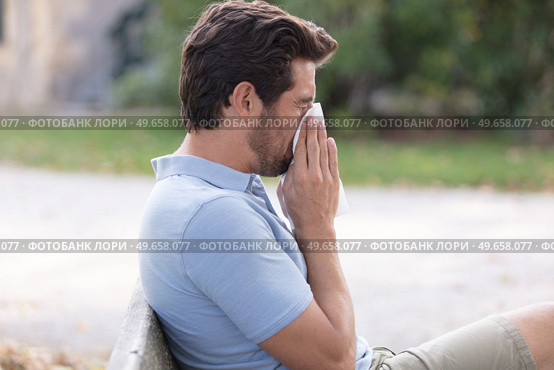 man with allergy or an infection sneezing. Стоковое фото, агентство Ingram Publishing / Фотобанк Лори