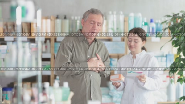 Man with heart pain choosing pills with help of pharmacist. Стоковое видео, видеограф Яков Филимонов / Фотобанк Лори