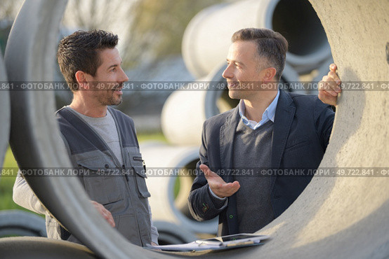 manager and worker next to concrete drainage pipe. Стоковое фото, агентство Ingram Publishing / Фотобанк Лори