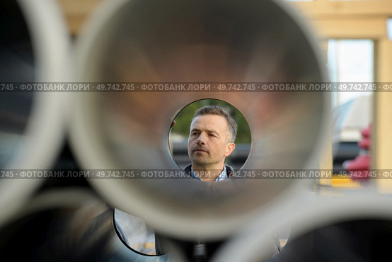 manager checks pipes laid at each other in a stack. Стоковое фото, агентство Ingram Publishing / Фотобанк Лори