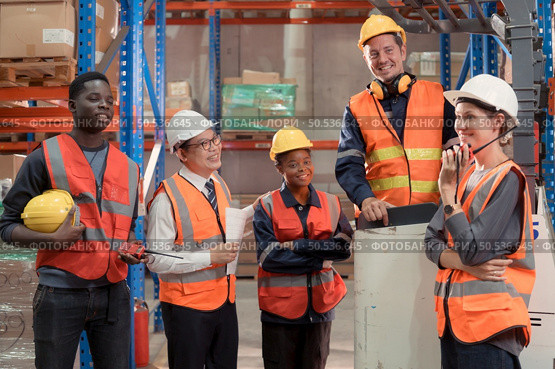 Managers, foremen and warehouse workers Consult together about getting the goods out of the warehouse to finish sending the small merchants tonight. Стоковое фото, агентство Ingram Publishing / Фотобанк Лори