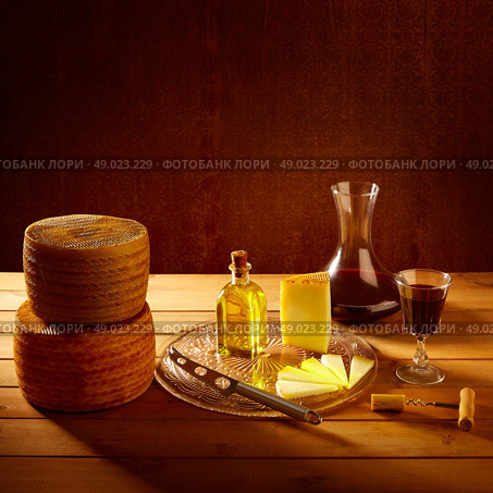 Manchego cheese from Spain with olive oil and red wine on wood. Стоковое фото, агентство Ingram Publishing / Фотобанк Лори