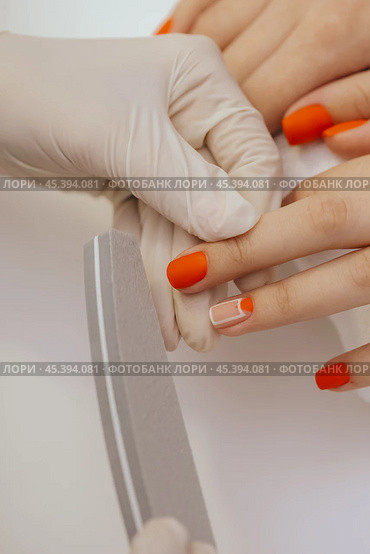 manicure worker smoothing customers nails with nail file. Стоковое фото, фотограф Сергей Толмачёв / Фотобанк Лори