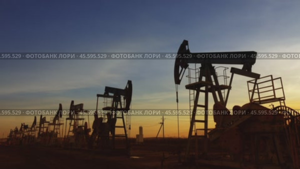 Many working oil pumps silhouette against sunset. Стоковое видео, видеограф Михаил Коханчиков / Фотобанк Лори