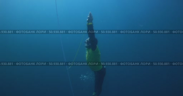 March 04, 2024. Nusa Penida, Indonesia. Men freediver in wetsuit training underwater on deep in ocean. Professional freediving in blue sea. Стоковое видео, видеограф Wonderful nature / Фотобанк Лори