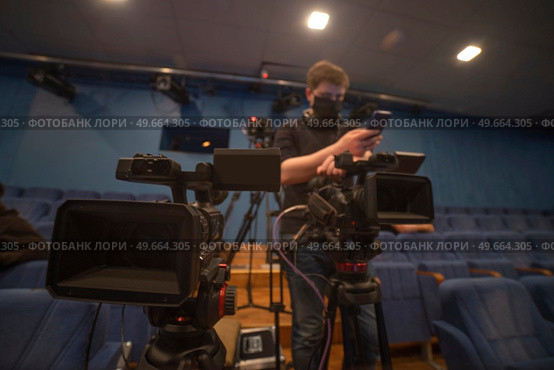 masked cameraman is filming a television show in the studio. TV. Стоковое фото, агентство Ingram Publishing / Фотобанк Лори