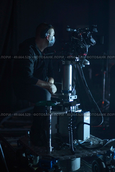 masked cameraman is filming a television show in the studio. TV. Стоковое фото, агентство Ingram Publishing / Фотобанк Лори