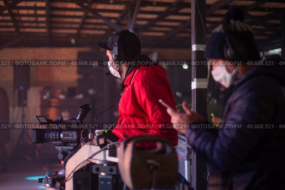 masked cameraman is filming a television show in the studio. TV. Стоковое фото, агентство Ingram Publishing / Фотобанк Лори