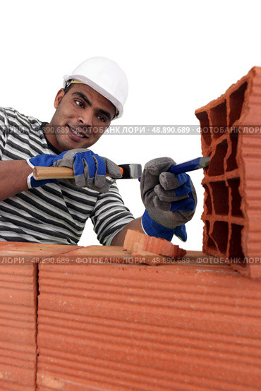 Mason chiseling away at brick. Стоковое фото, агентство Ingram Publishing / Фотобанк Лори