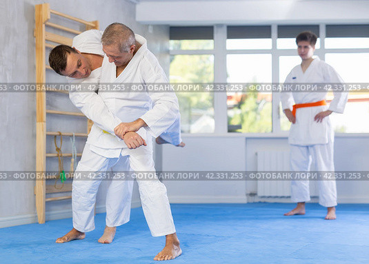 Mature men working on martial arts techniques and maneuvers in training fight. Стоковое фото, фотограф Яков Филимонов / Фотобанк Лори