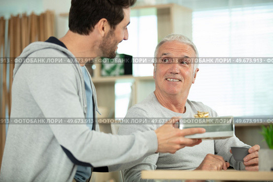 mature son congratulating elderly father. Стоковое фото, агентство Ingram Publishing / Фотобанк Лори