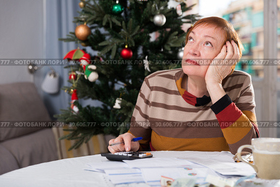 Mature woman calculates utility costs in the new year. Стоковое фото, фотограф Яков Филимонов / Фотобанк Лори