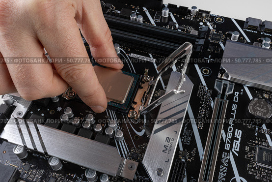 Maykop, Russia - February 18, 2025: A man's hand installs a new Intel processor into an Asus motherboard socket close-up. Редакционное фото, фотограф Андрей С / Фотобанк Лори