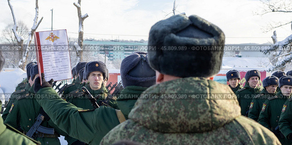 Maykop, Russia - January 13, 2024: A young soldier takes the military oath on the parade ground in front of a line of soldiers on a winter morning. Редакционное фото, фотограф Андрей С / Фотобанк Лори