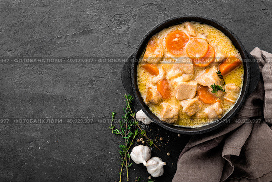 Meat stew, chicken fillet in sauce with carrot in a cast iron pot, top view. Стоковое фото, агентство Ingram Publishing / Фотобанк Лори