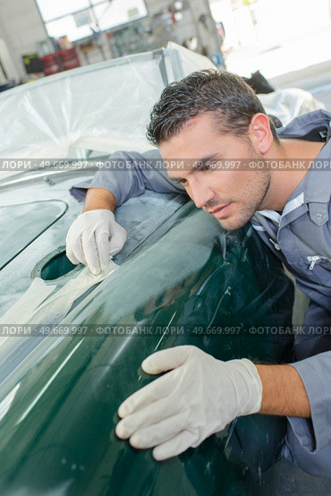 Mechanic assessing wing of classic car. Стоковое фото, агентство Ingram Publishing / Фотобанк Лори