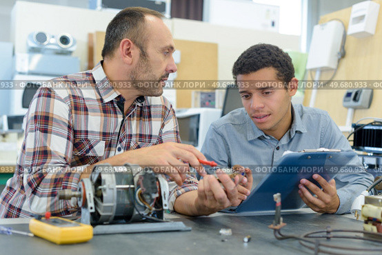 mechanic showing engines to apprentices low angle. Стоковое фото, агентство Ingram Publishing / Фотобанк Лори