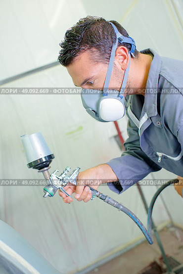 Mechanic spraying paint. Стоковое фото, агентство Ingram Publishing / Фотобанк Лори