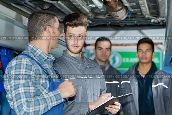 mechanic teaching trainees in garage workshop. Стоковое фото, агентство Ingram Publishing / Фотобанк Лори