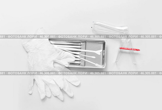 Medical gloves with gynecological speculum and pap smear test tools on light background. Стоковое фото, фотограф Pixel_shot / Фотобанк Лори