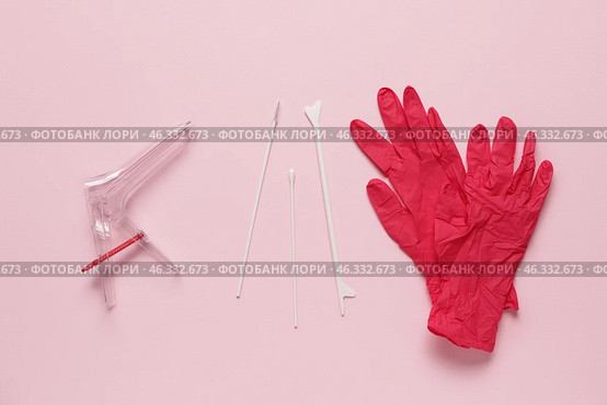 Medical gloves with gynecological speculum and pap smear test tools on pink background. Стоковое фото, фотограф Pixel_shot / Фотобанк Лори