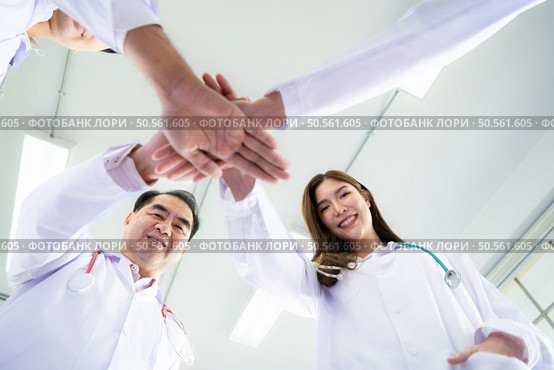 Medical teams encourage each other before treating seriously ill patients in the hospital. Стоковое фото, агентство Ingram Publishing / Фотобанк Лори