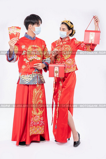 Men and women wear cheongsam welcome to get - get gift money and red bag for traditional day. Стоковое фото, агентство Ingram Publishing / Фотобанк Лори
