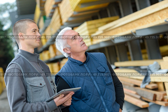 Men looking at wood in materials outlet. Стоковое фото, агентство Ingram Publishing / Фотобанк Лори