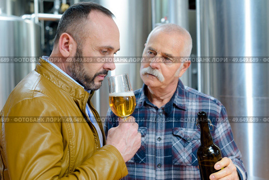 men smelling and testing craft beer at brewery. Стоковое фото, агентство Ingram Publishing / Фотобанк Лори