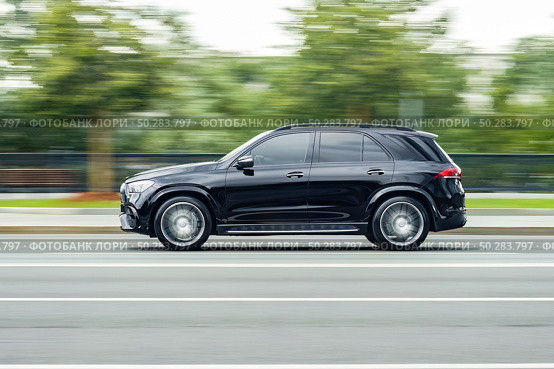 Mercedes-AMG GLE 53 car driving in city with motion blur, view from the side. Редакционное фото, фотограф Константин Григорьев / Фотобанк Лори