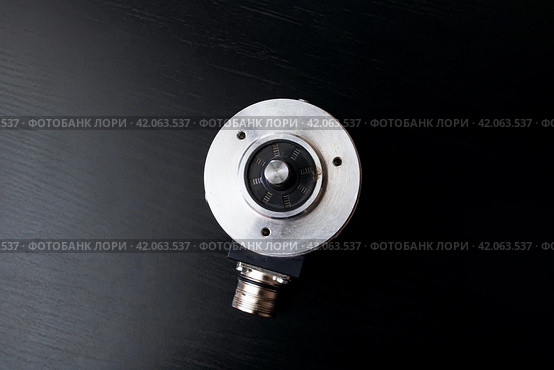 Metal encoder on a black wooden table. Стоковое фото, фотограф Аксенова Вера / Фотобанк Лори