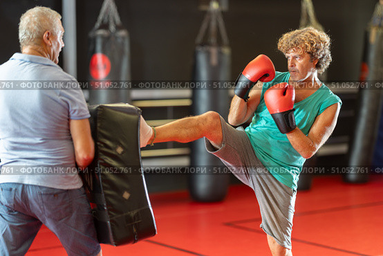 Middle‑aged man striking shield in self‑defense drill. Стоковое фото, фотограф Яков Филимонов / Фотобанк Лори