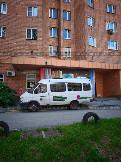 Микроавтобус у жилого дома из красного кирпича в Нижнем Новгороде. Редакционное фото, фотограф Мария Сергеева / Фотобанк Лори