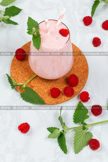 Milkshake with raspberries in a glass glass with melissa leaves in the design. Стоковое фото, фотограф Неведицына Елена / Фотобанк Лори