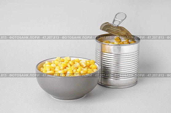 Миска и консервная банка с консервированной кукурузой на сером фоне. Стоковое фото, фотограф Pixel_shot / Фотобанк Лори