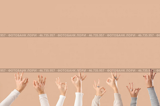 Многие руки показывают жест "ОК" на бежевом фоне. Стоковое фото, фотограф Pixel_shot / Фотобанк Лори