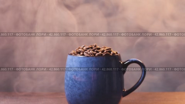 Много макро ароматных, кофейных зерен в чашке и дым на фоне. Стоковое видео, видеограф Останина Екатерина / Фотобанк Лори