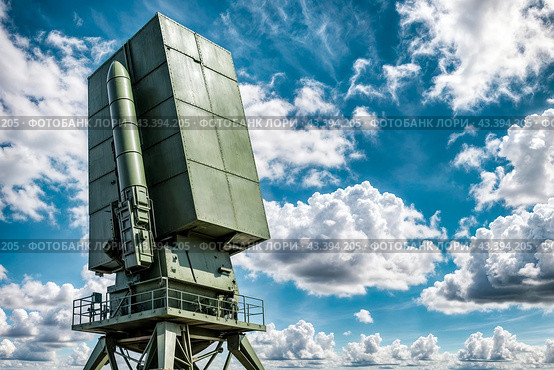 Modern air defence radar of military mobile missile launcher system of green color at blue cloudy sky background. Air defense installation outdoors. Concept of modern army industry. Copy ad text space. Стоковое AI-изображение, AI-художник Aleksandr Golubev / Фотобанк Лори