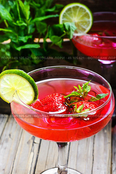Mojito with lime and strawberry. alcohol cocktail in glass on a long stalk with strawberries and lime. Стоковое фото, агентство Ingram Publishing / Фотобанк Лори