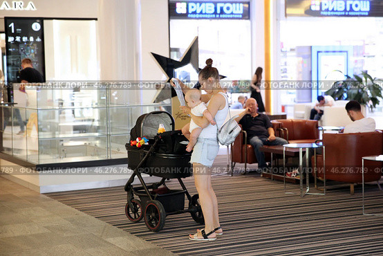 Молодая мама с грудным ребенком, подгузником и детской коляской. Vegas Crocus city Mall. Москва. 27.07.2018. Редакционное фото, фотограф Ольга Зиновская / Фотобанк Лори