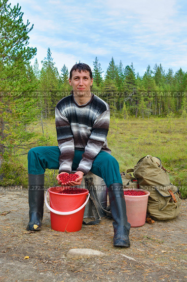 Молодой человек с урожаем брусники. Стоковое фото, фотограф Кекяляйнен Андрей / Фотобанк Лори