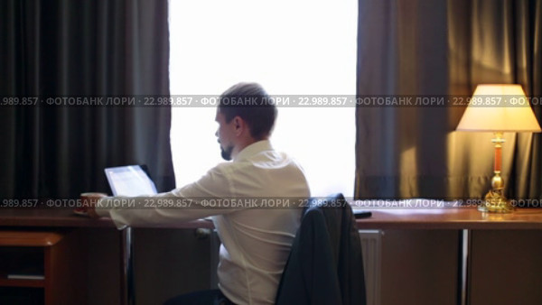 Молодой менеджер работает на компьютере в номере гостиницы. Стоковое видео, видеограф Виталий Зверев / Фотобанк Лори