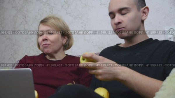 Mom and son communicate with relatives via video link on a laptop and show them apples from the new harvest. Стоковое видео, видеограф Ярославский Максим / Фотобанк Лори