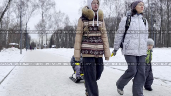 Mom and three children walk along the path of the winter park. Стоковое видео, видеограф Ярославский Максим / Фотобанк Лори