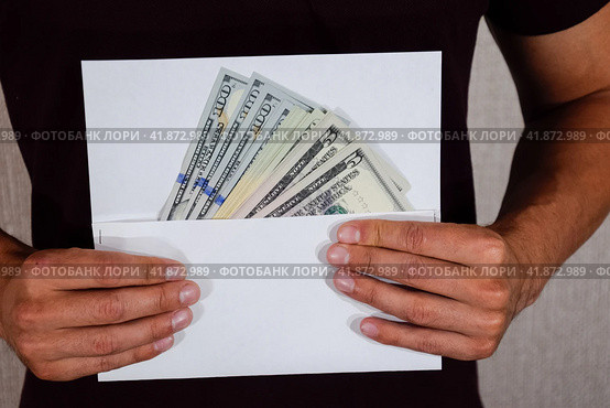 Money in white envelope in the hands of a man. Dollars, a wad of dollars. Стоковое фото, фотограф Леонид Еремейчук / Фотобанк Лори