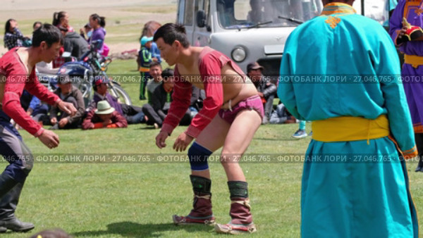 Mongolian wrestlers wrestling in nature. Spectators in national clothes watch the competition (2017 год). Редакционное видео, видеограф Сергей Пристяжнюк (Serg Zastavkin) / Фотобанк Лори